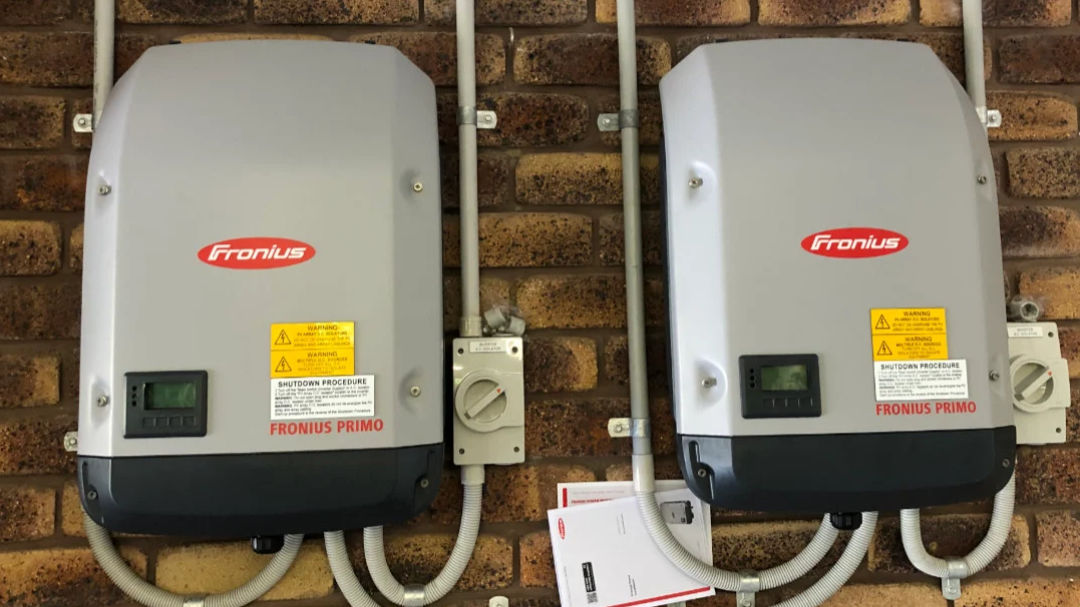 String Inverter Image of two string inverters mounted on a brick wall.